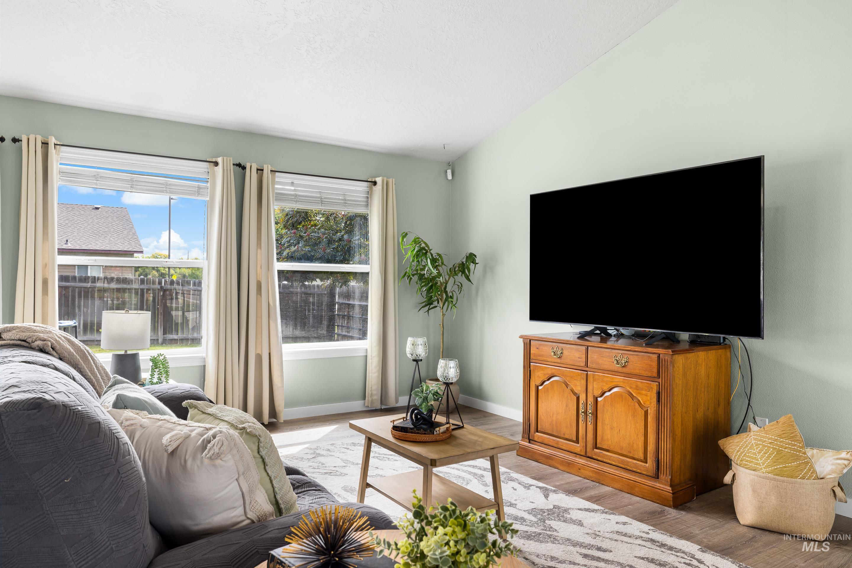 Living area featuring light wood-style flooring and lofted ceiling