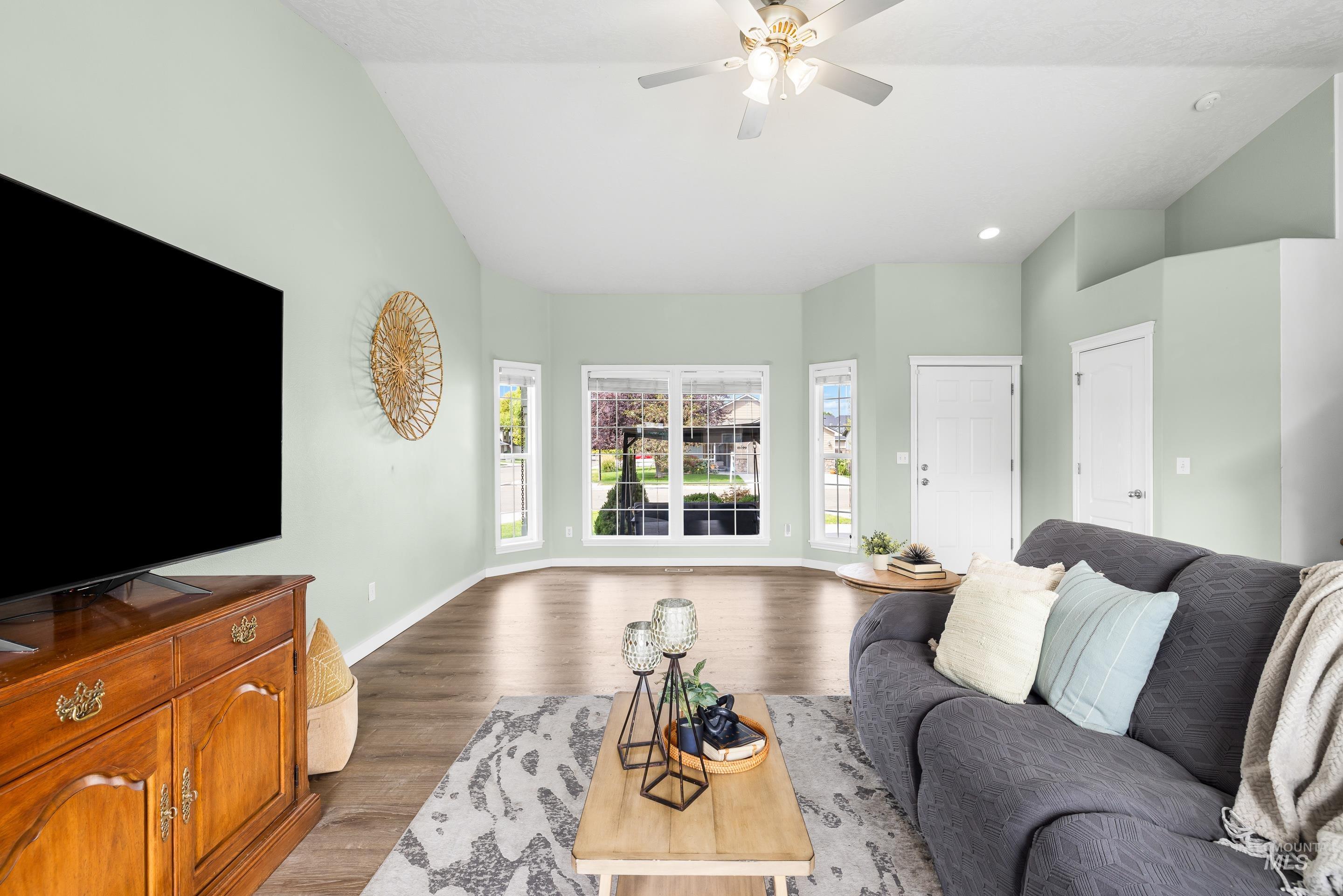 Living area with vaulted ceiling, light wood finished floors, a ceiling fan, and recessed lighting