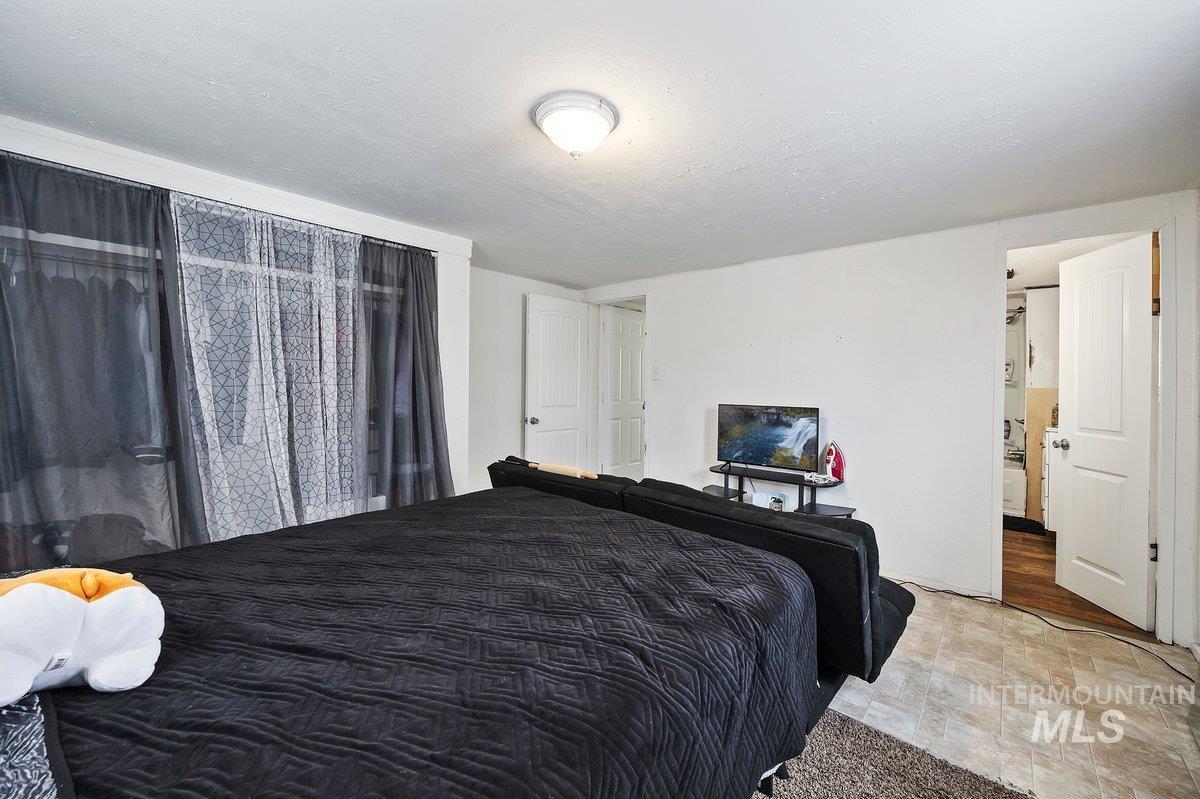 Bedroom with a textured ceiling and stone finish flooring