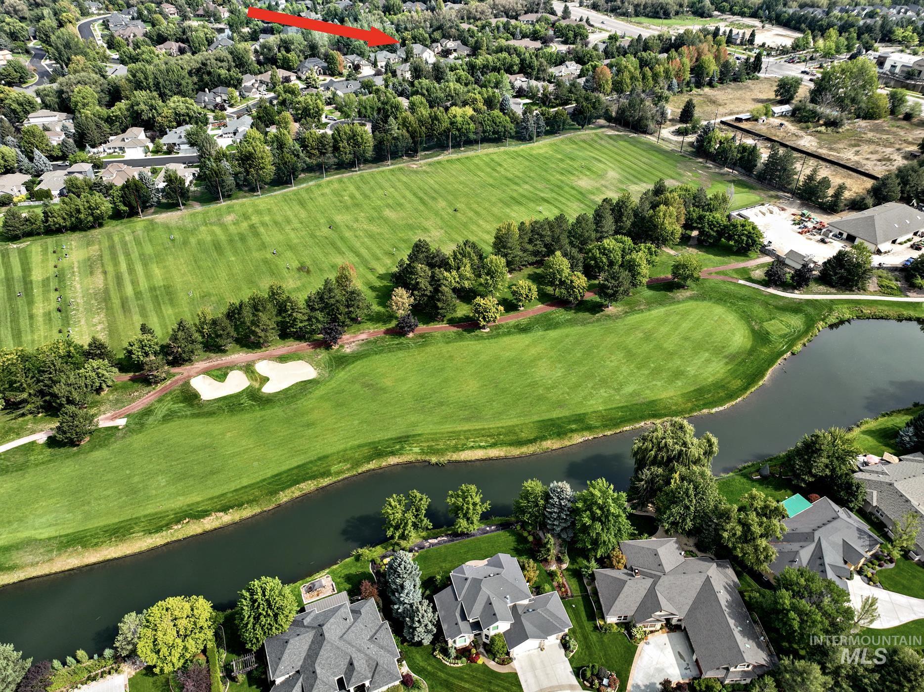 Aerial overview of property's location with a nearby body of water, nearby suburban area, and a local golf course