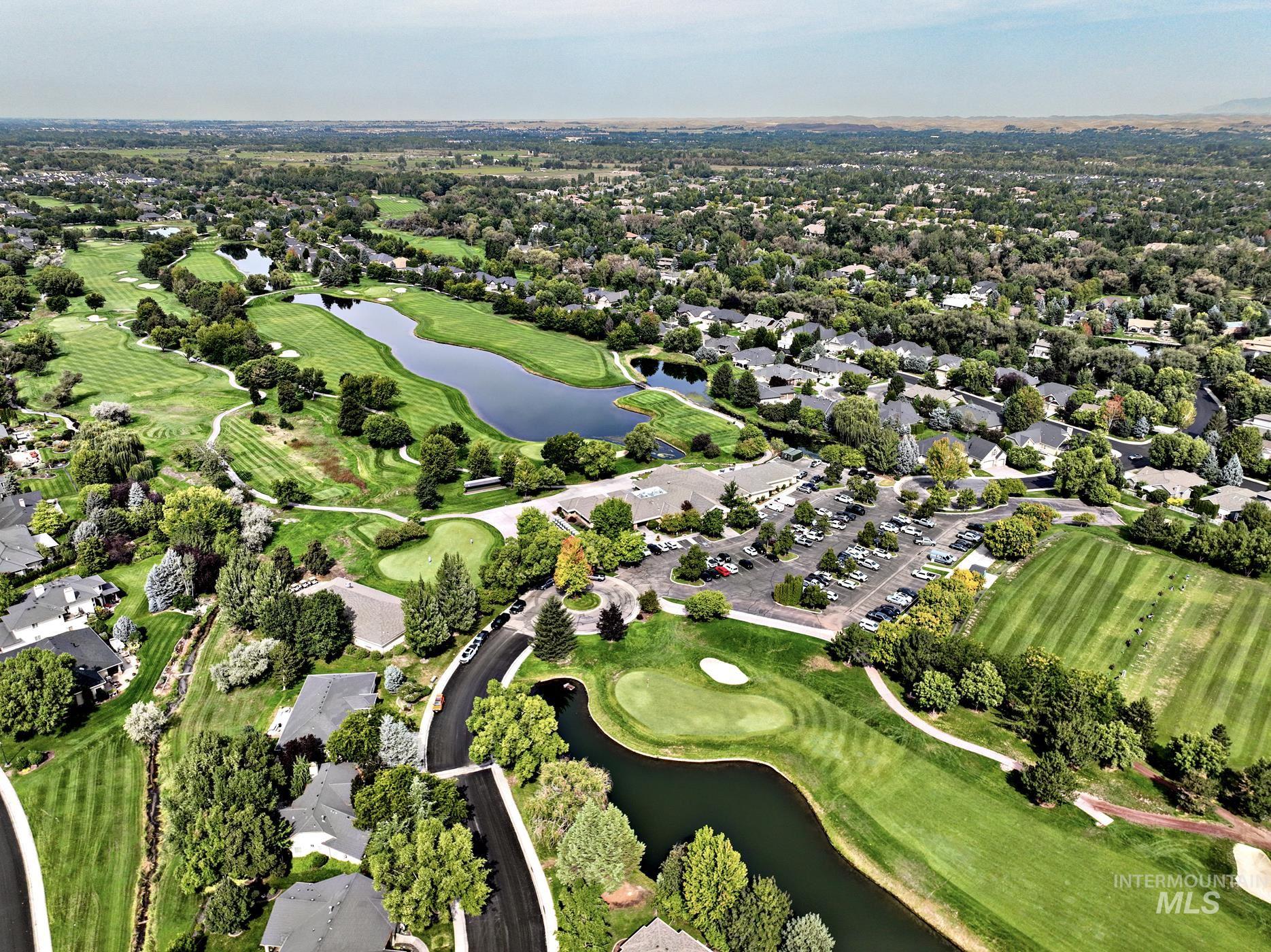 Aerial view of property's location with a large body of water, a local golf course, and nearby suburban area