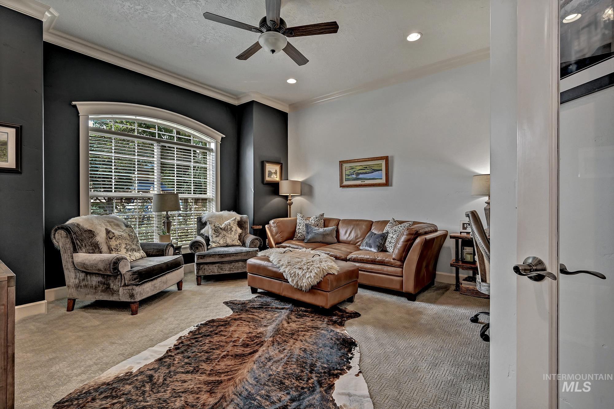 Carpeted living room with a textured ceiling, ornamental molding, ceiling fan, and recessed lighting