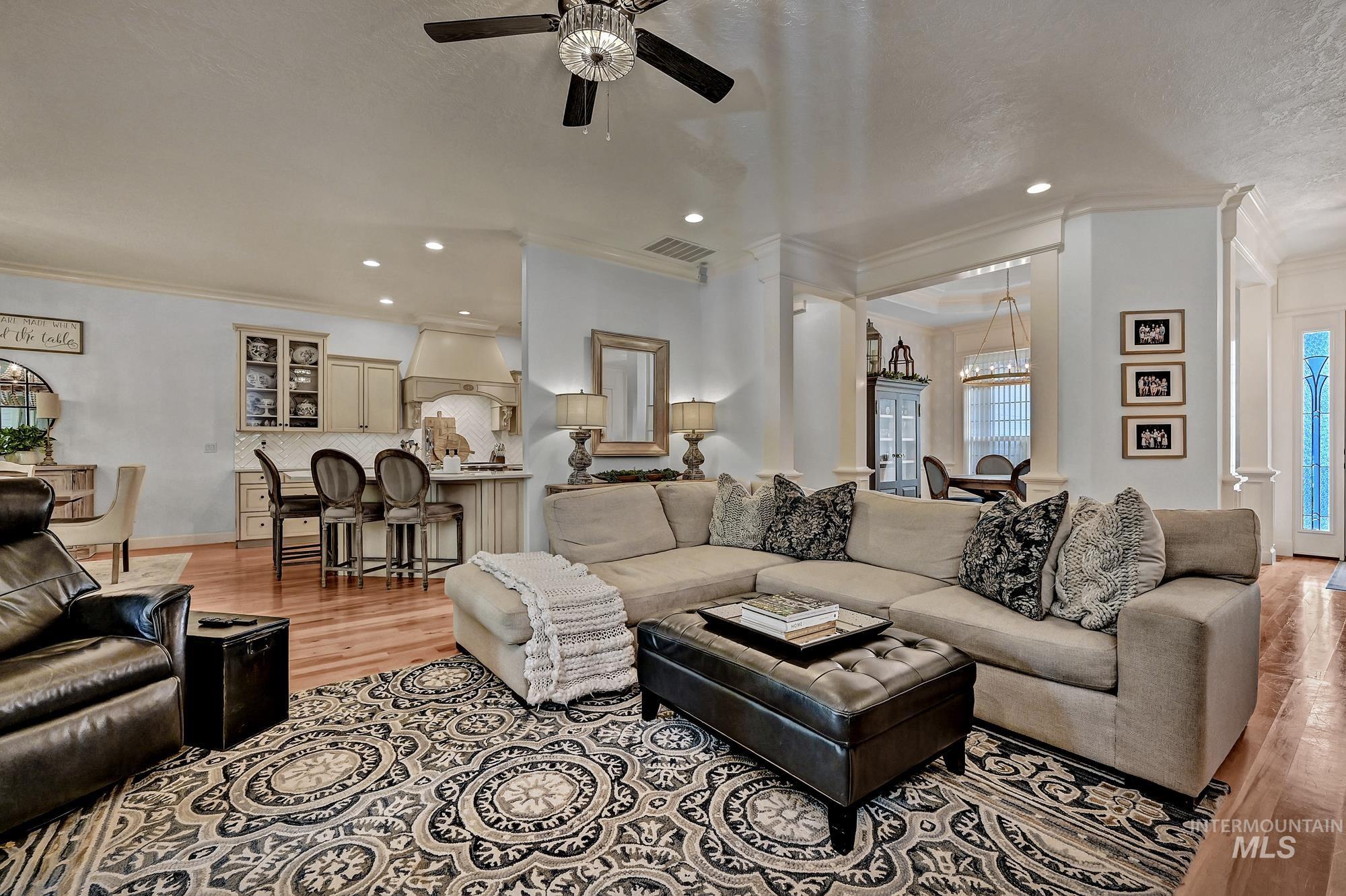 Living area featuring crown molding, light wood-style flooring, a ceiling fan, and recessed lighting