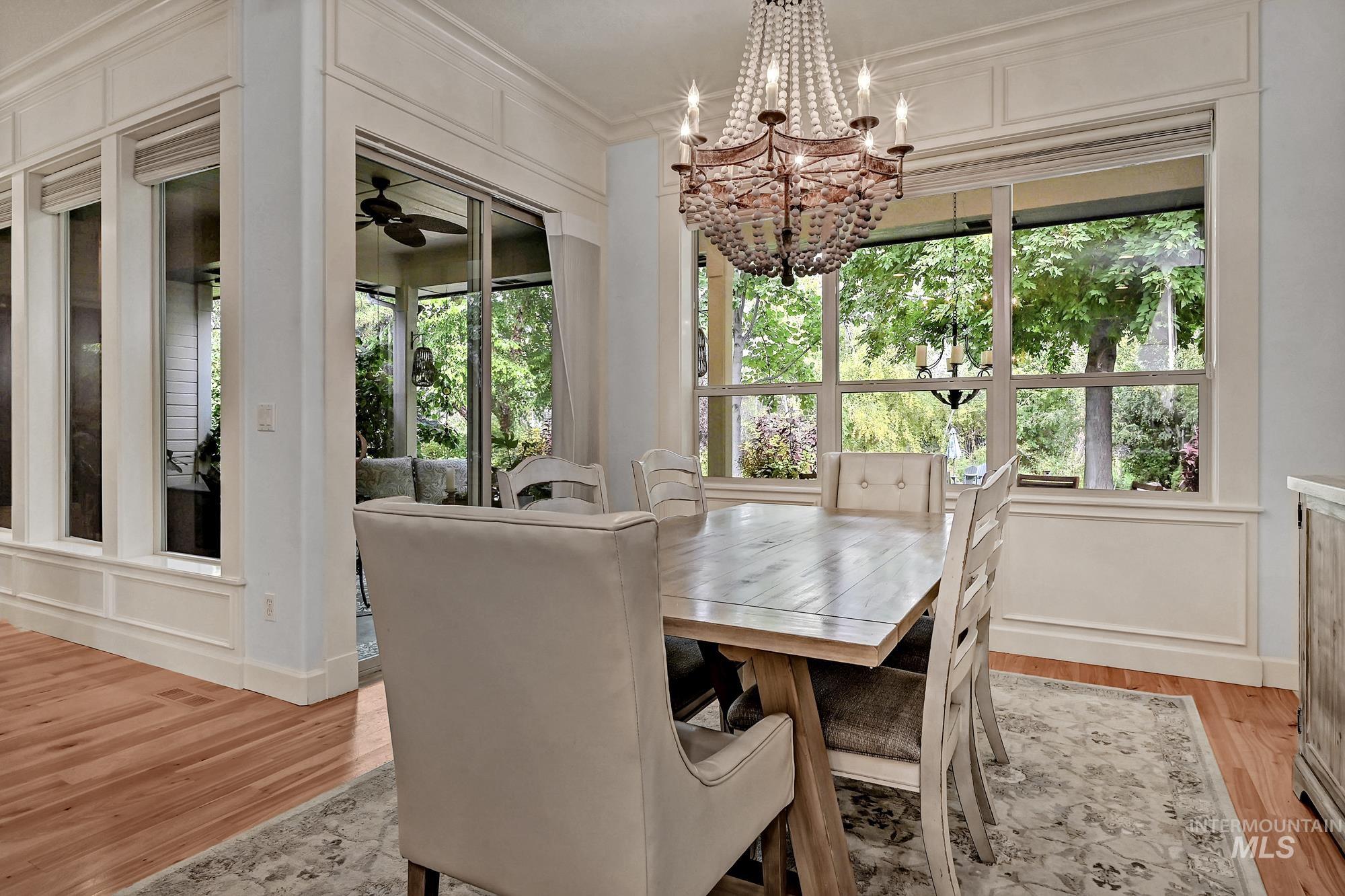 Dining space featuring light wood finished floors, a chandelier, and ornamental molding