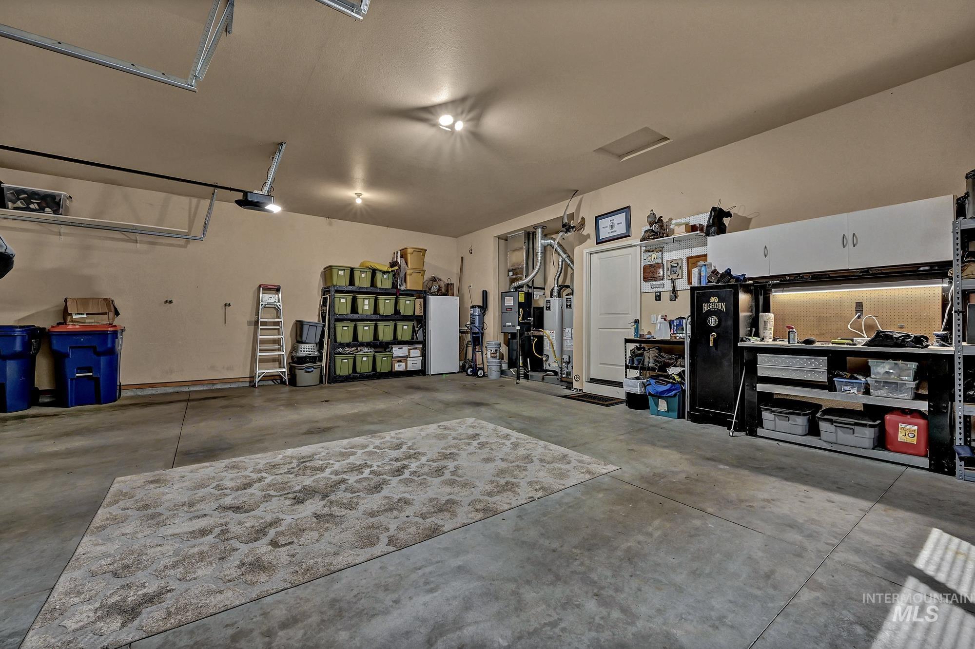 Garage with gas water heater and freestanding refrigerator