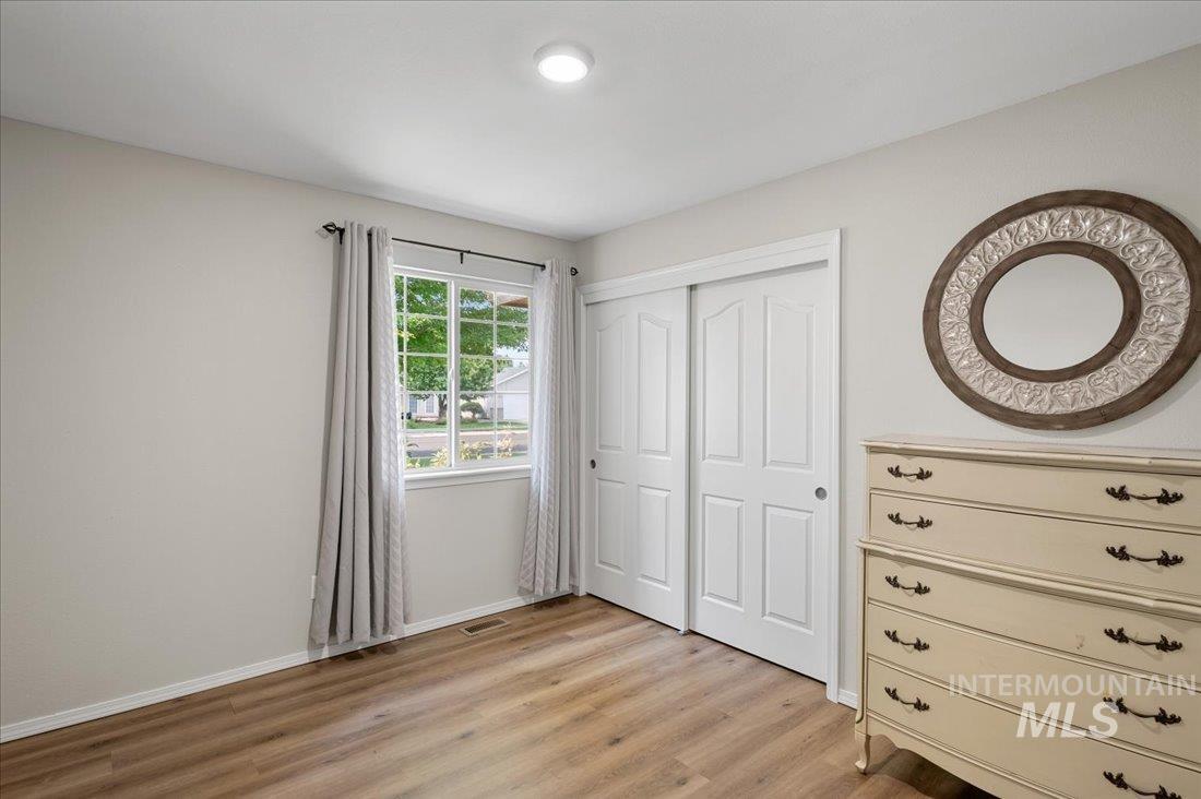 Bedroom with light wood finished floors and a closet