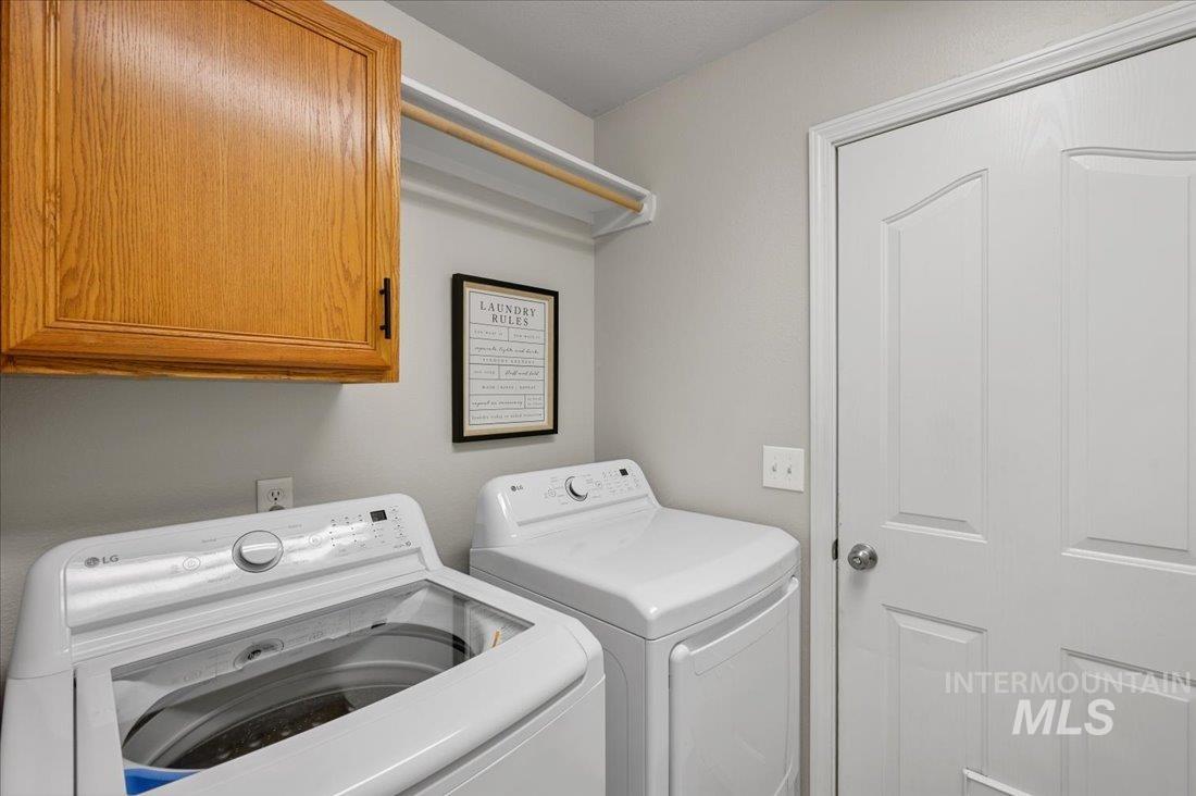 Washroom featuring separate washer and dryer and cabinet space