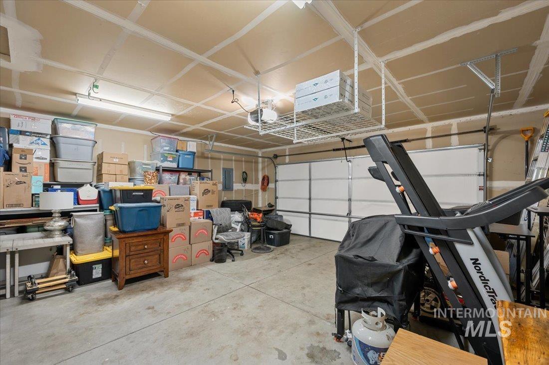 Garage featuring electric panel and a garage door opener