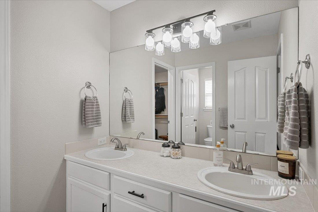 Bathroom featuring double vanity and toilet