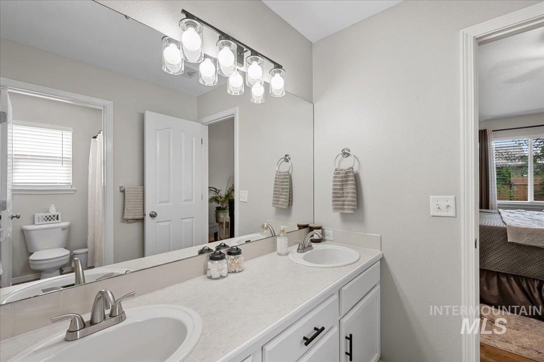 Ensuite bathroom featuring healthy amount of natural light and double vanity