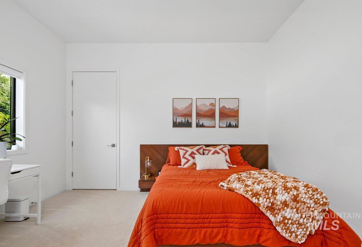 Bedroom featuring light colored carpet and baseboards