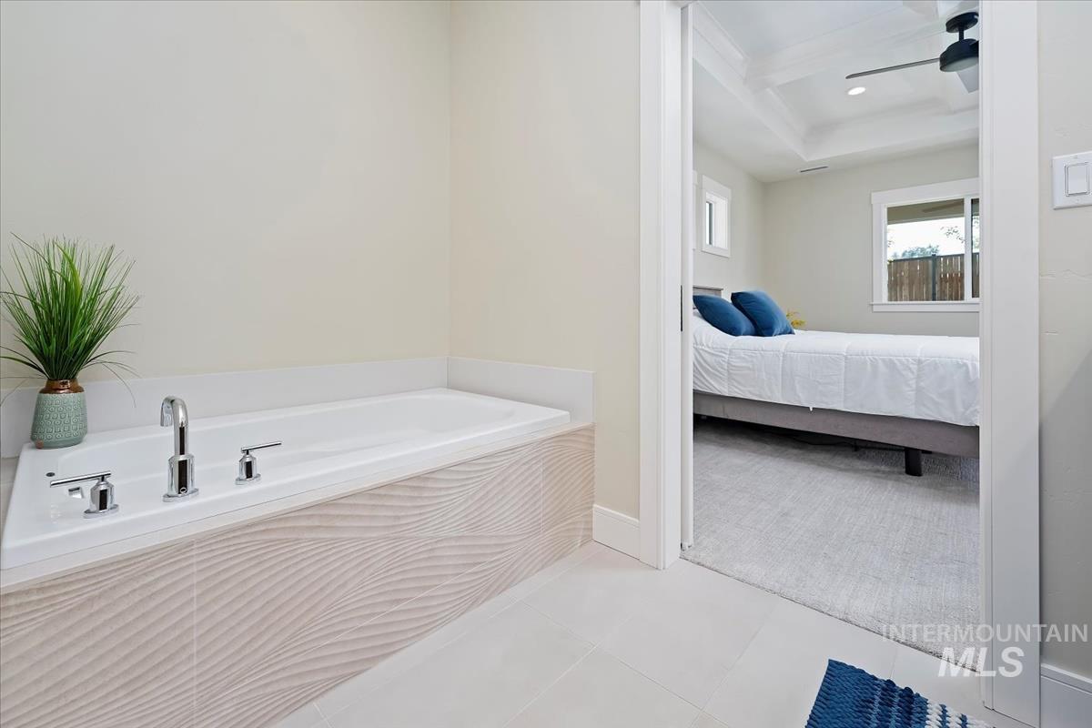 Full bathroom with a bath, connected bathroom, beam ceiling, light tile patterned floors, and ceiling fan