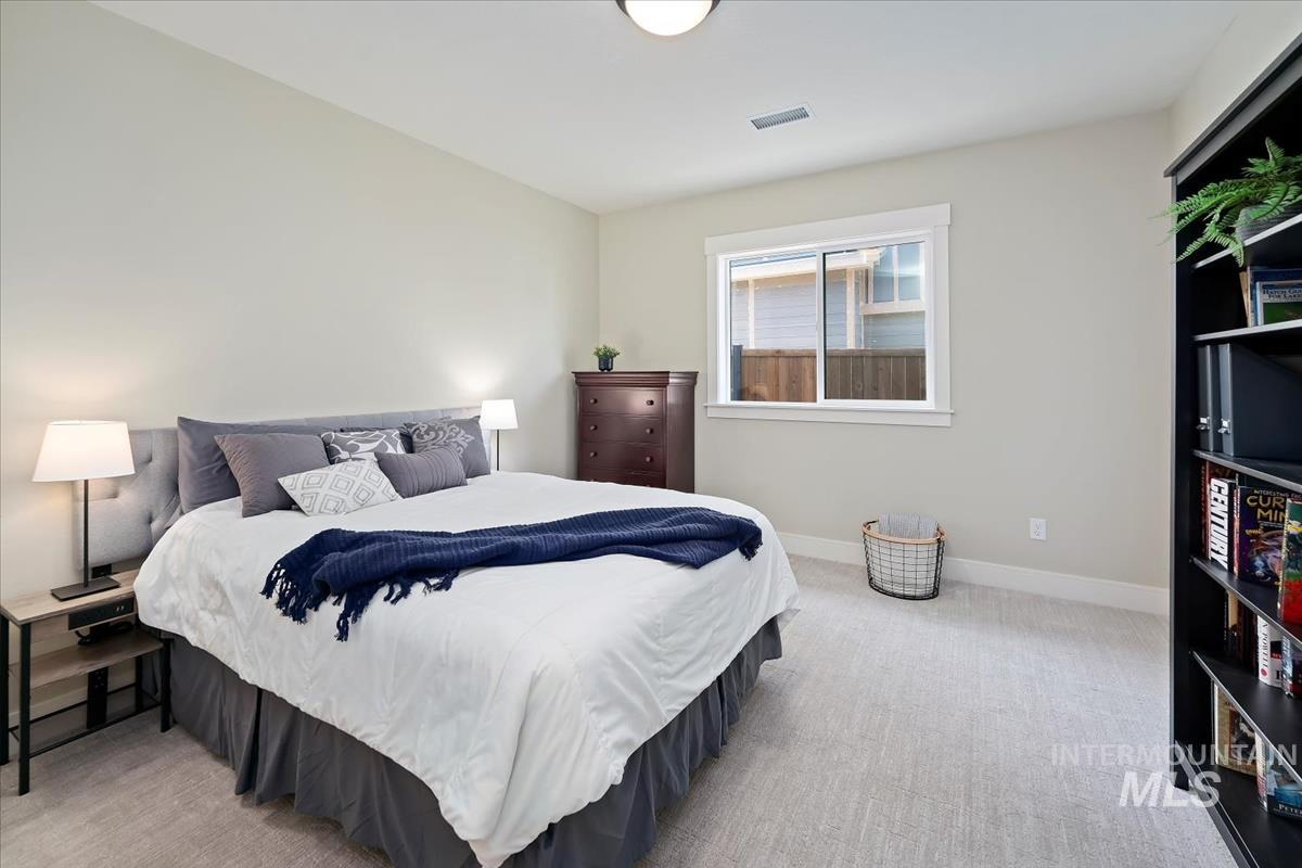 Bedroom with light carpet and baseboards