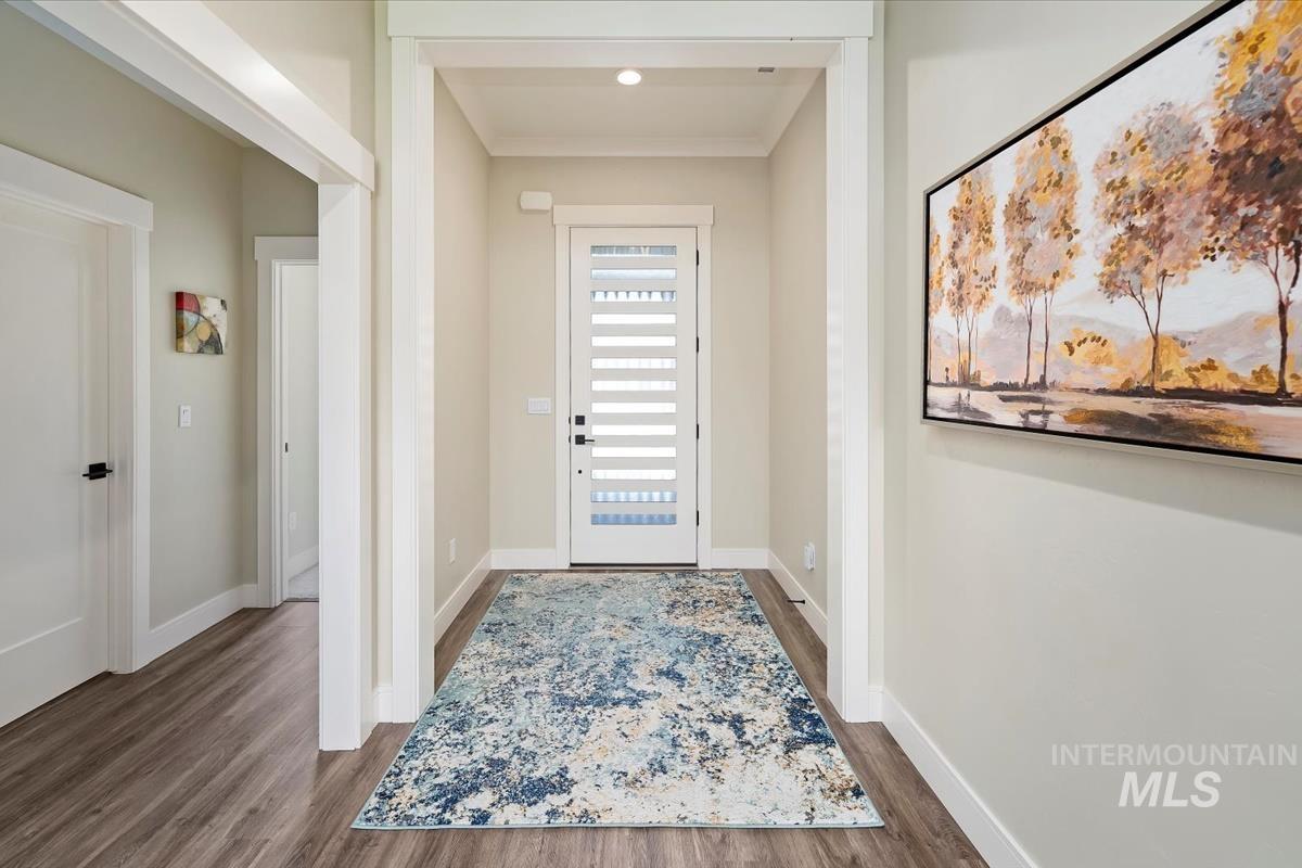 Foyer featuring dark wood finished floors and baseboards
