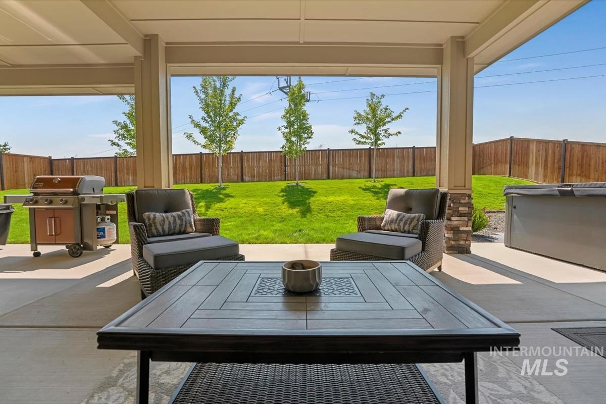 Fenced backyard featuring a patio, grilling area, and outdoor dining space