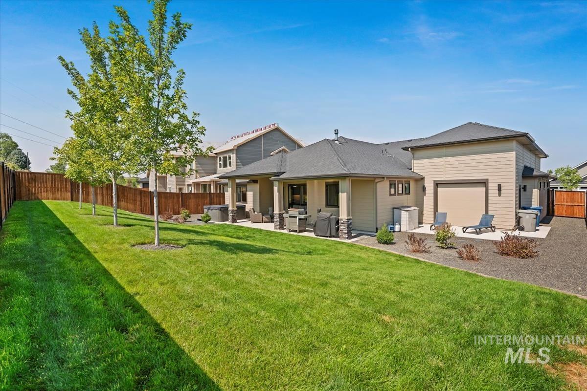 Rear view of property with a fenced backyard and a patio area