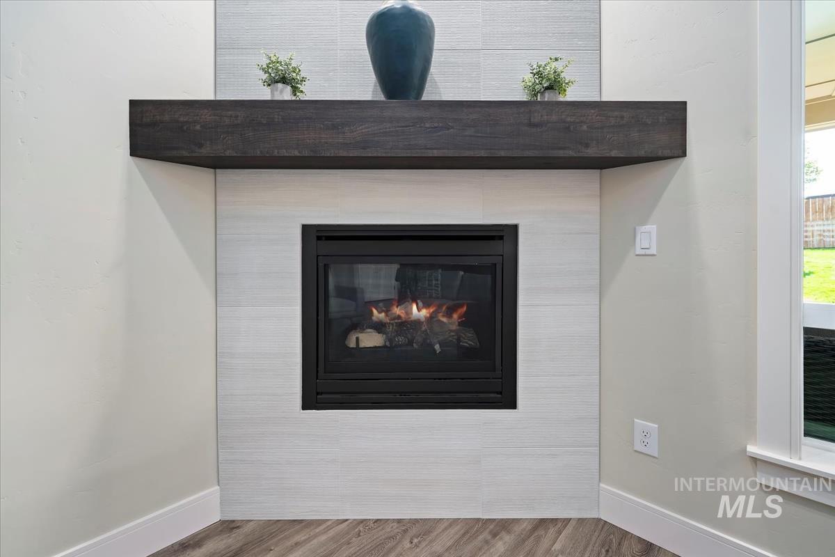 Detailed view of wood finished floors and a glass covered fireplace