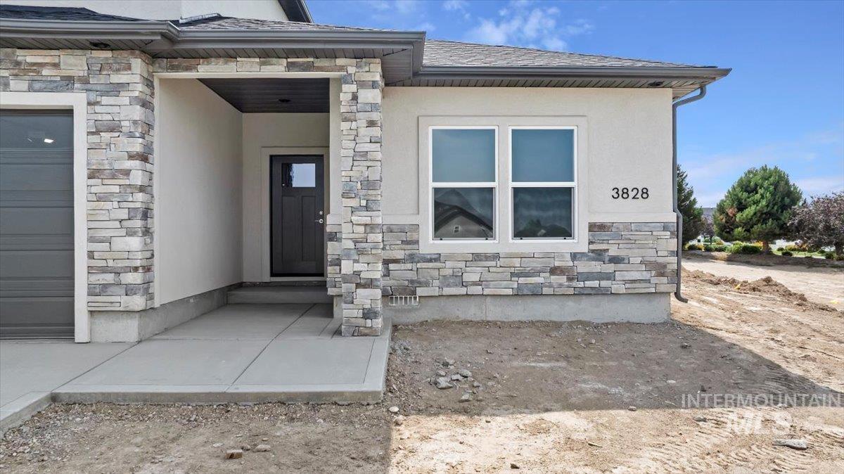 View of exterior entry with stone siding and stucco siding
