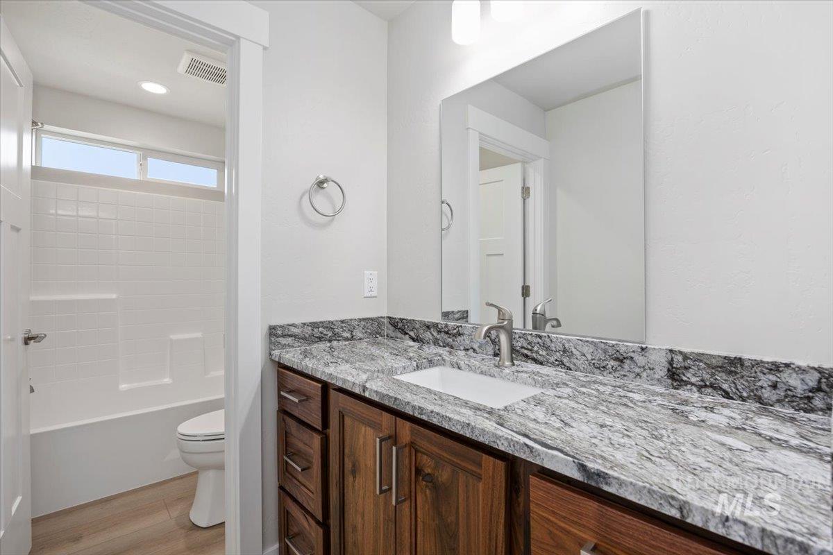 Bathroom featuring vanity, light wood finished floors, and washtub / shower combination