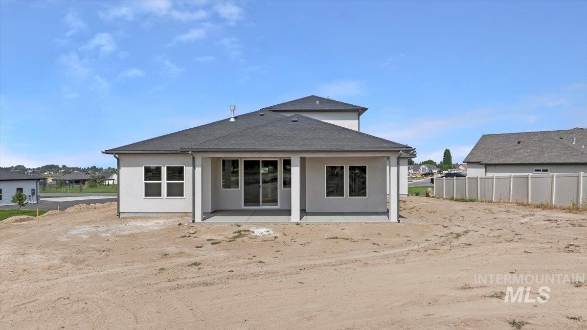 Rear view of property with a patio, roof with shingles, and stucco siding