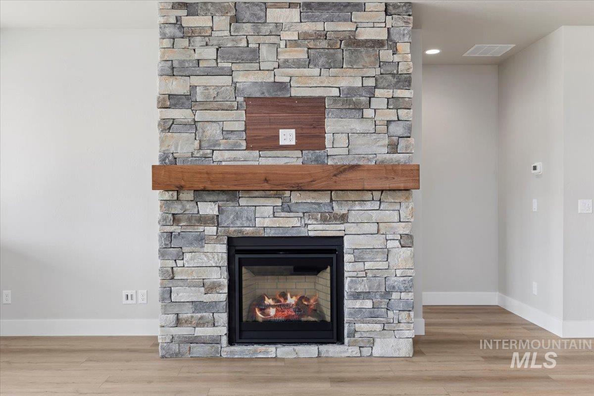 Detailed view of wood finished floors, a fireplace, and recessed lighting