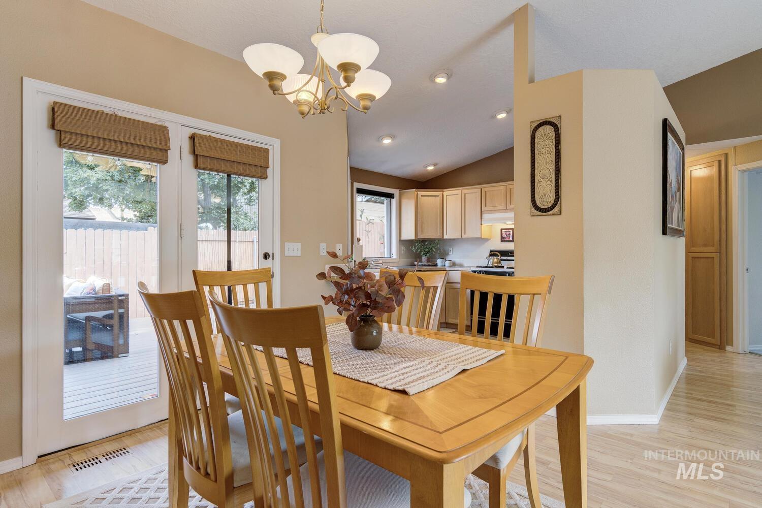 Dining area with lofted ceiling, light wood-style floors, recessed lighting, and a chandelier