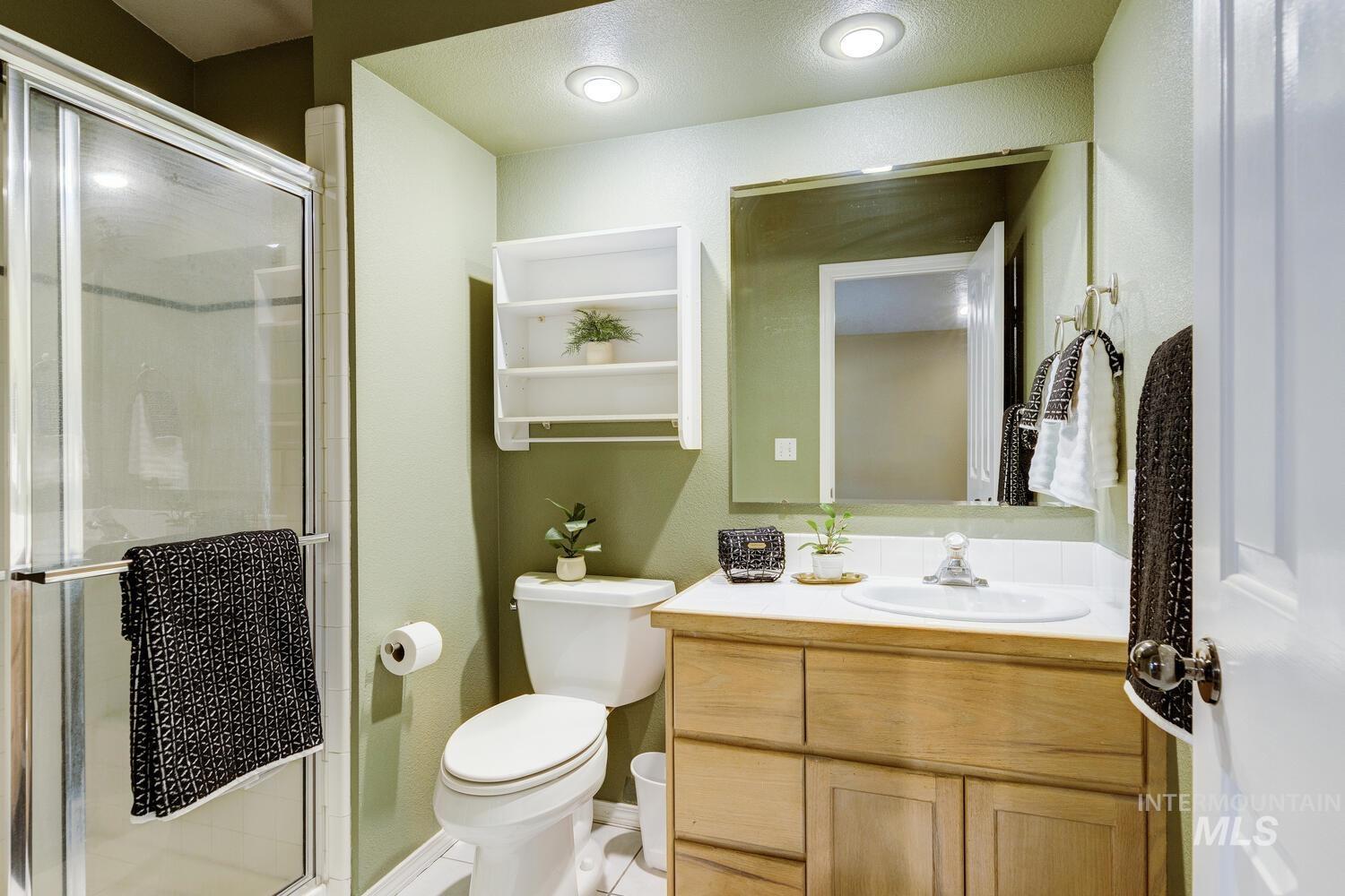 Full bath featuring vanity and a shower stall