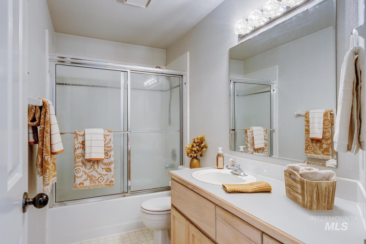 Full bath with enclosed tub / shower combo and vanity