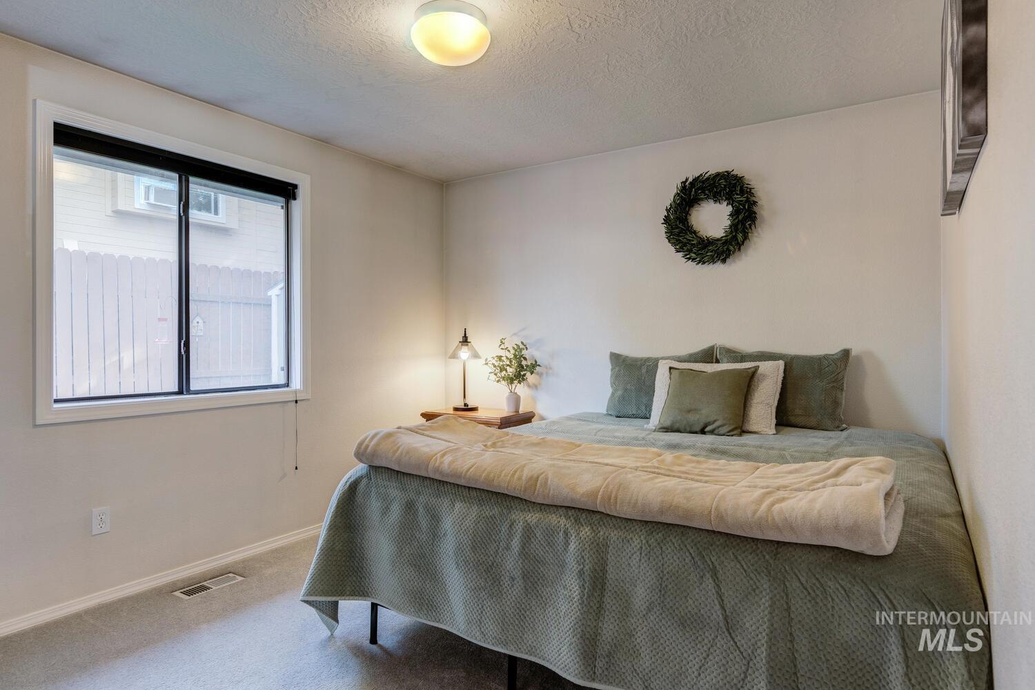 Bedroom with carpet floors and a textured ceiling