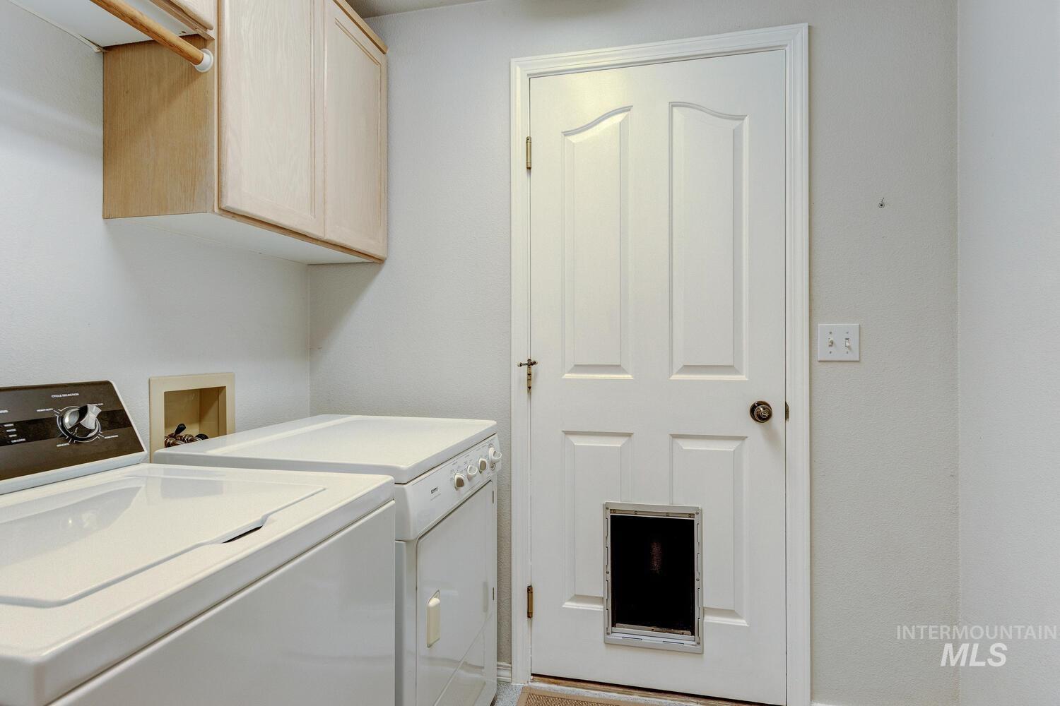 Washroom with cabinet space and washing machine and clothes dryer