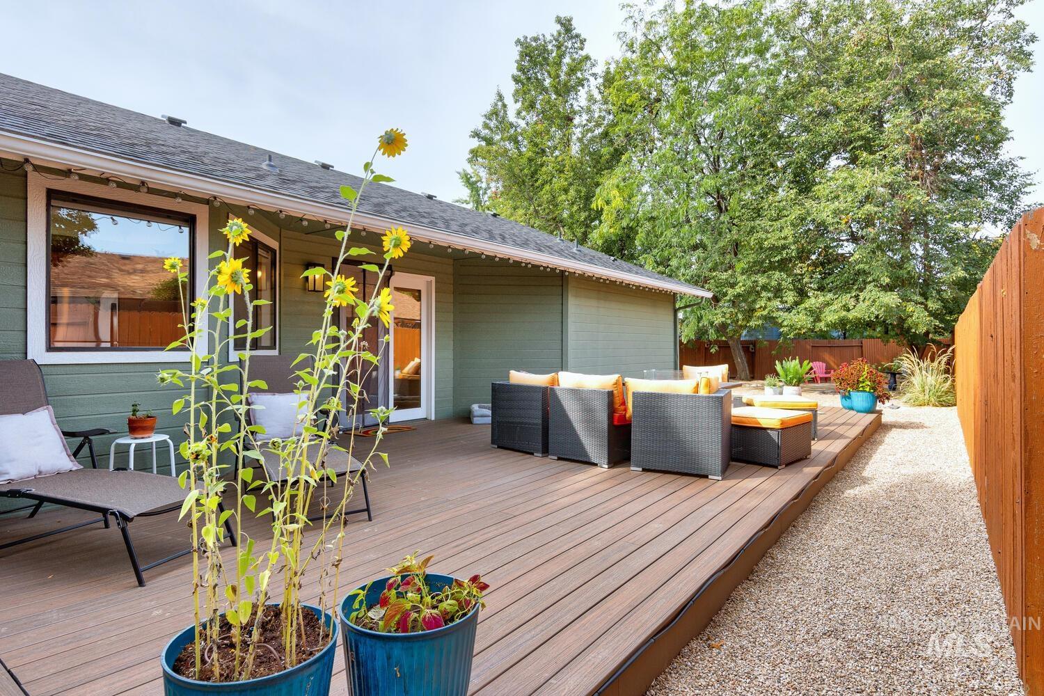 Wooden terrace featuring an outdoor living space and a fenced backyard
