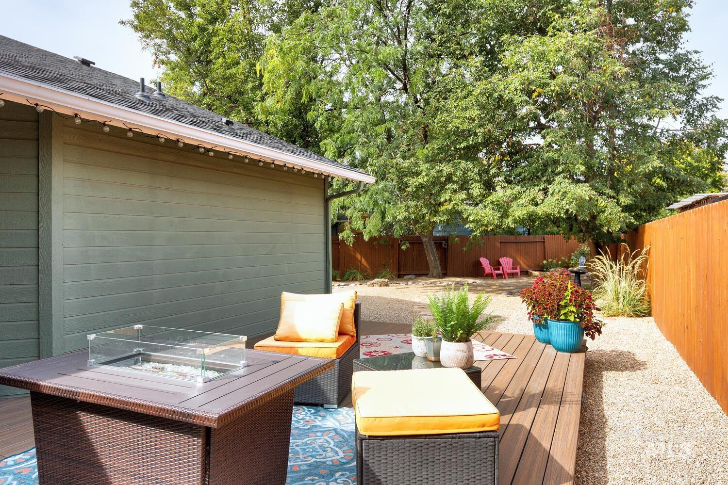 Fenced backyard with a patio, a deck, and an outdoor living space