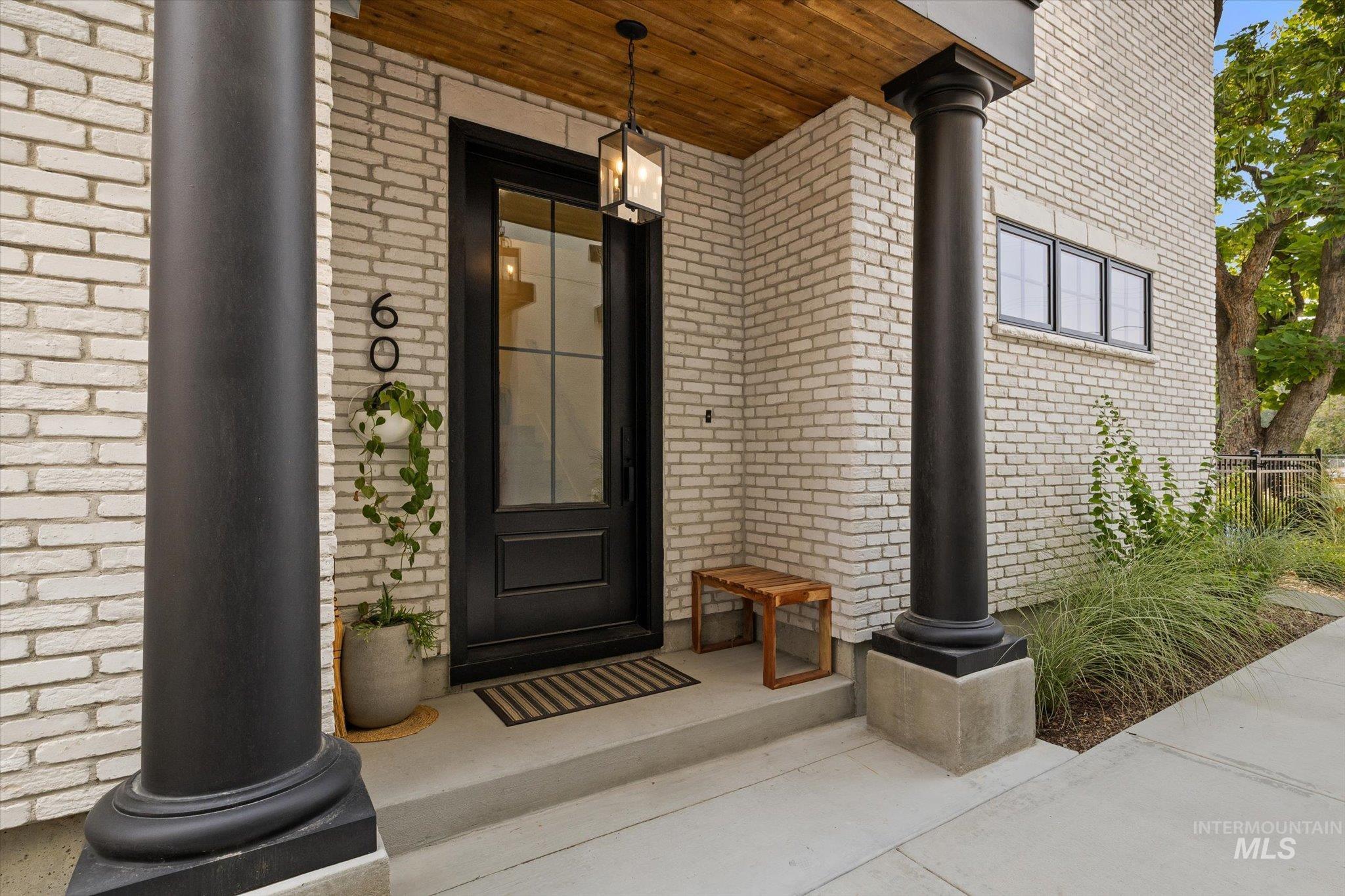 Entrance to property featuring brick siding and covered porch