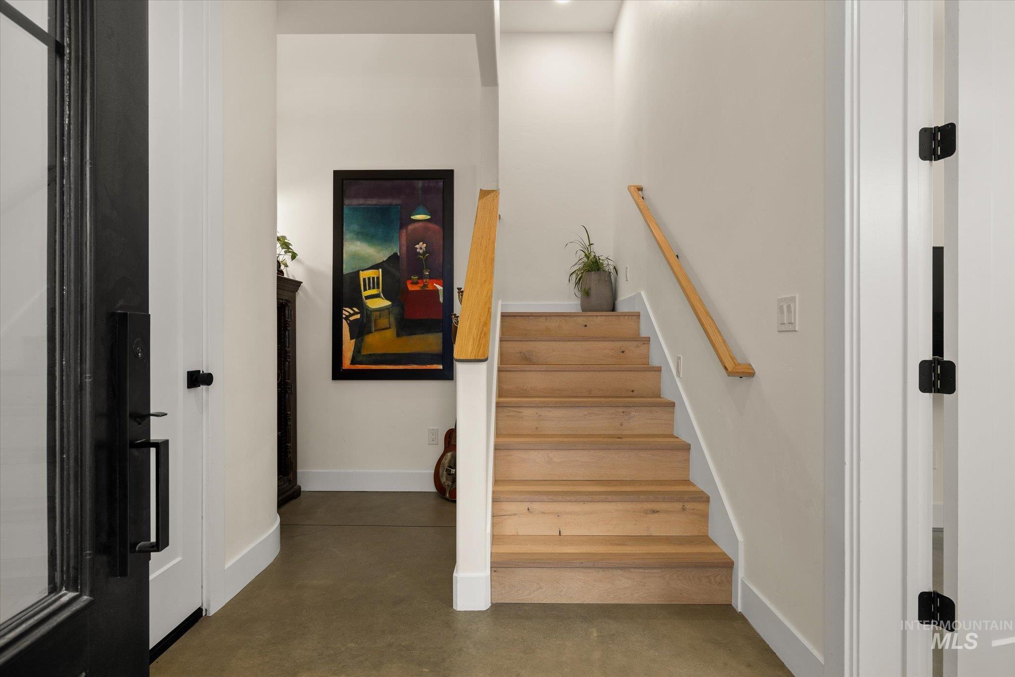 Stairway featuring finished concrete floors and baseboards