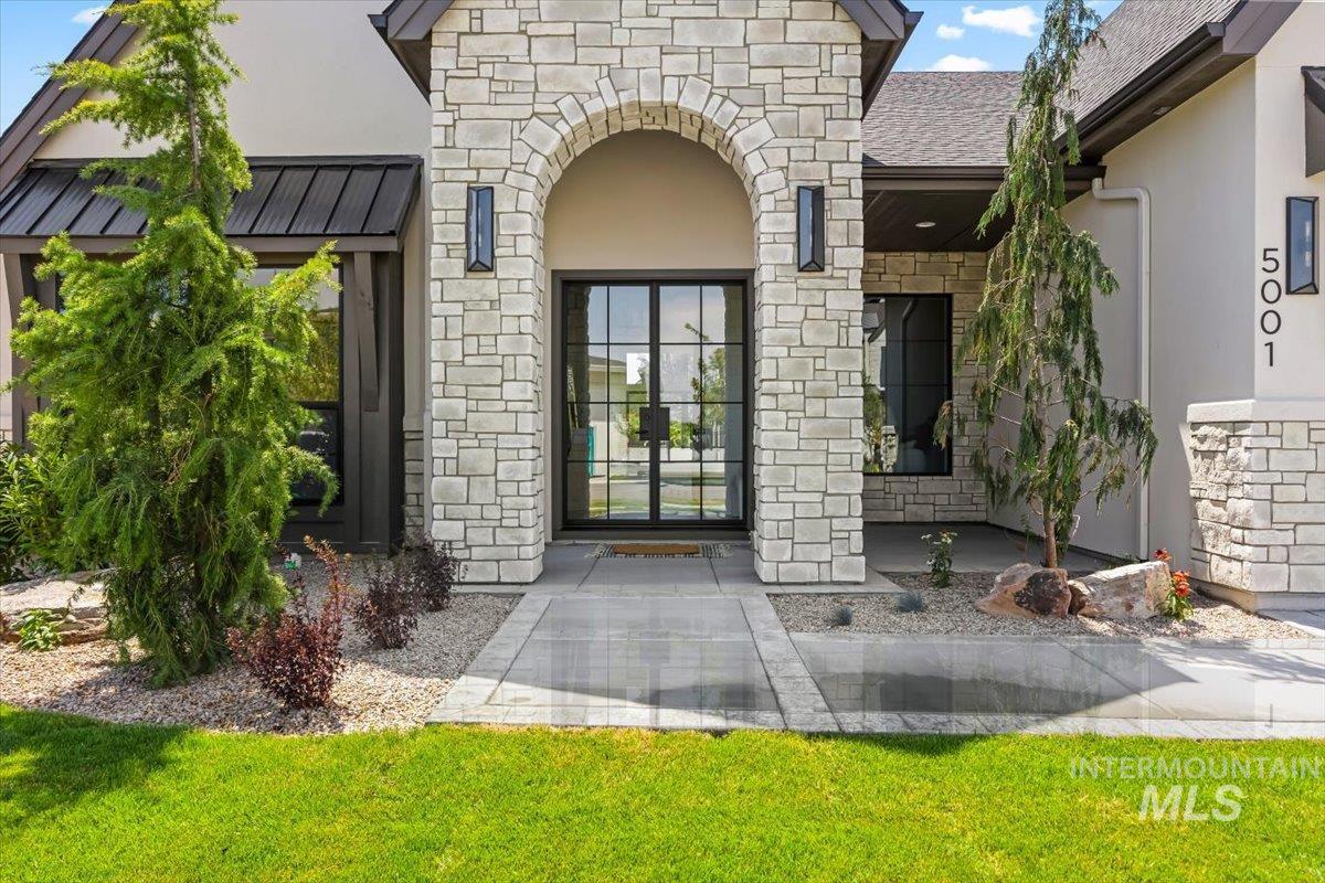 Property entrance featuring stone siding and stucco siding