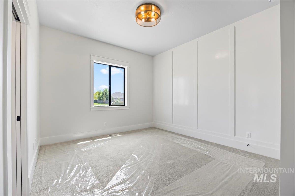 Carpeted empty room with baseboards