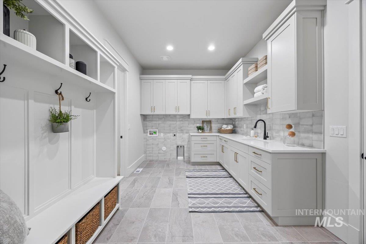 Mudroom featuring recessed lighting and a sink