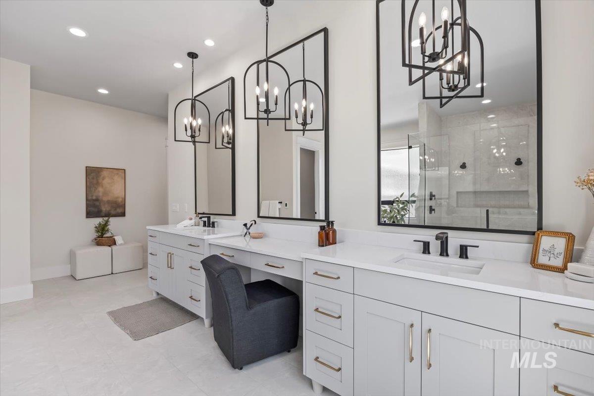 Bathroom with a stall shower, vanity, and recessed lighting