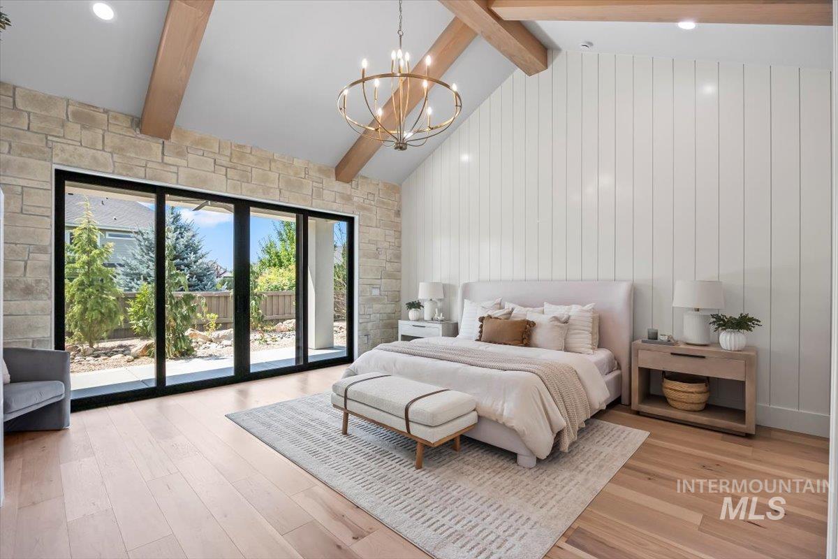 Bedroom with beamed ceiling, access to exterior, light wood-style flooring, high vaulted ceiling, and a chandelier