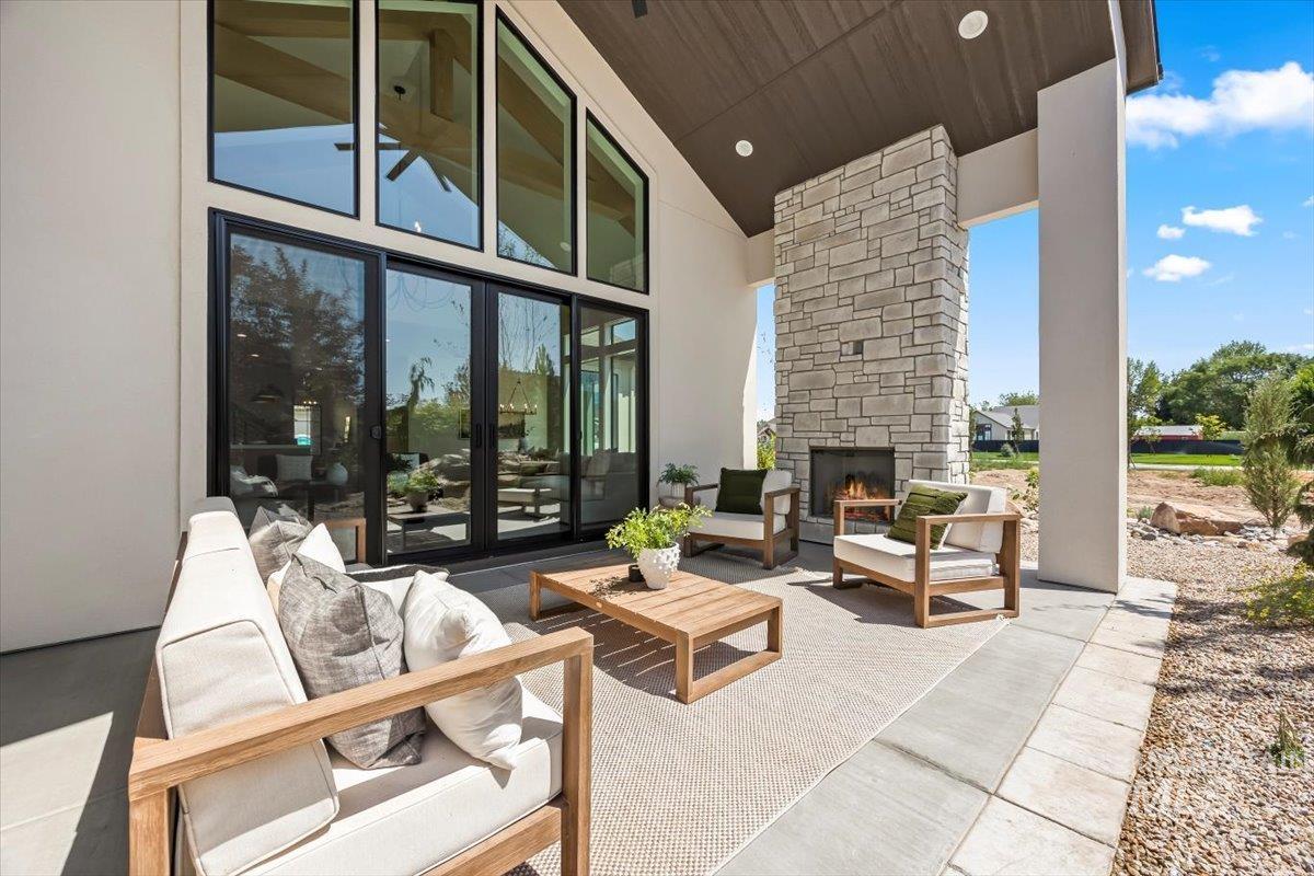 View of patio with french doors and an outdoor living space with a fireplace