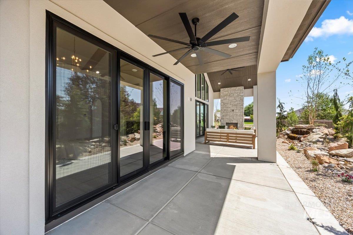 View of patio / terrace with an outdoor stone fireplace and ceiling fan