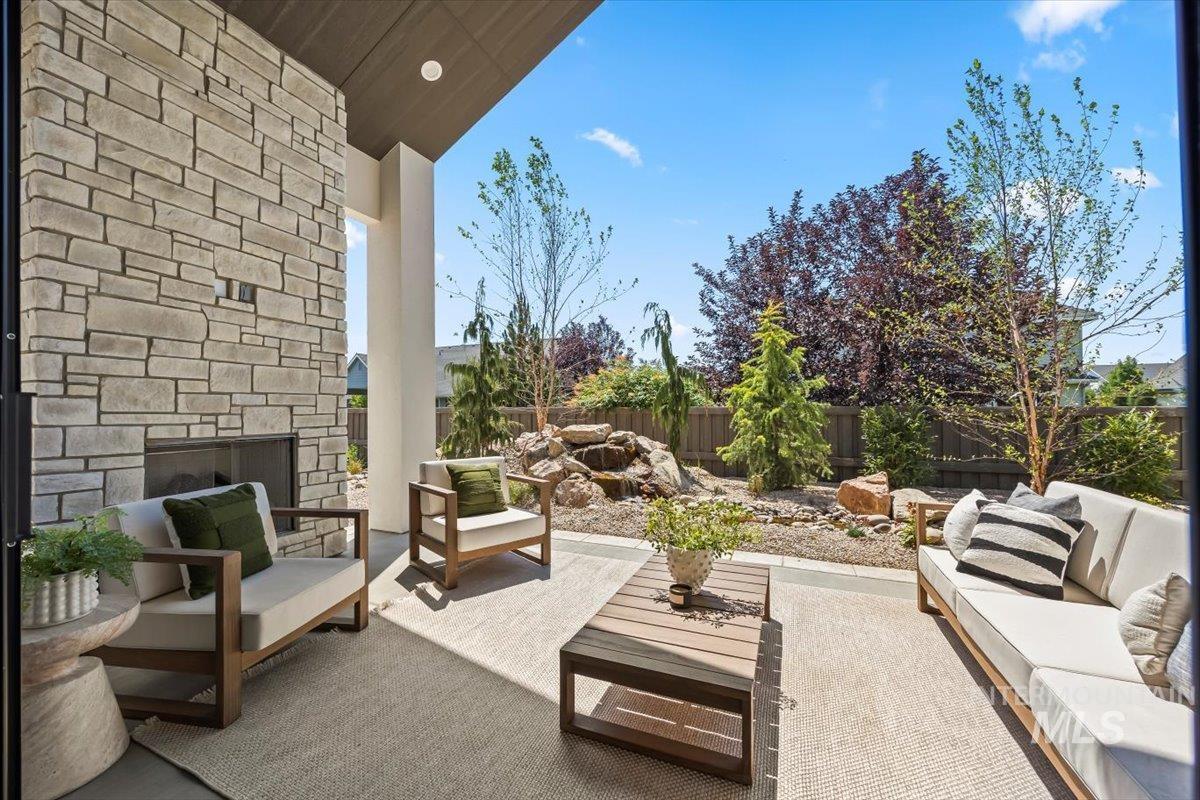 Fenced backyard featuring an outdoor living space with a fireplace and a patio