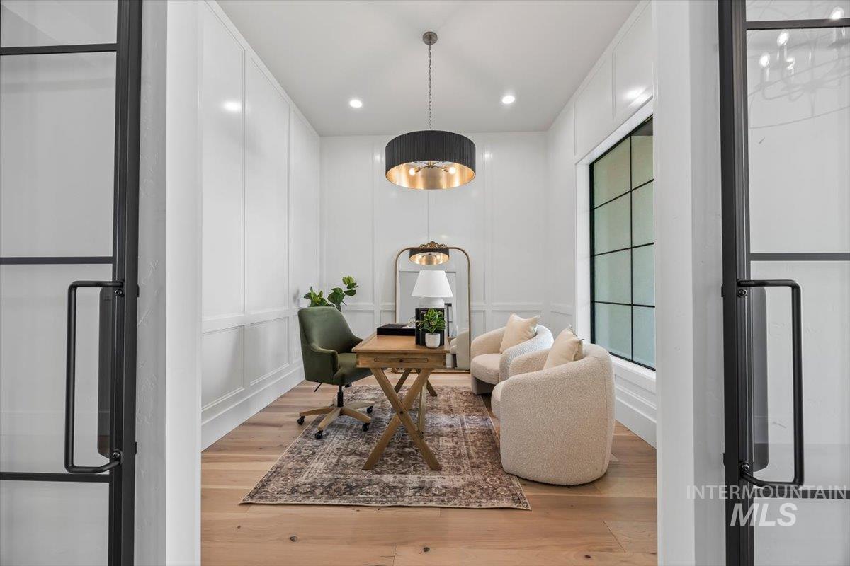 Office space with a decorative wall, light wood-style floors, and recessed lighting