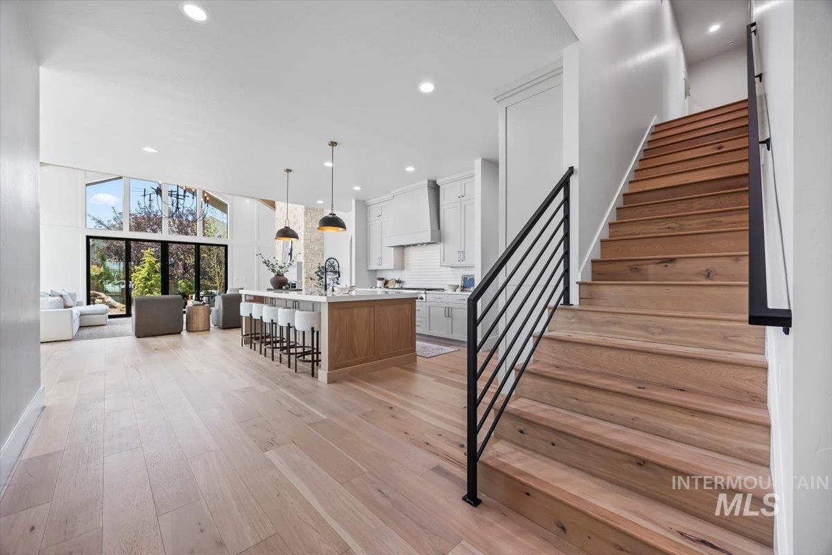 Staircase featuring wood finished floors, recessed lighting, and a towering ceiling