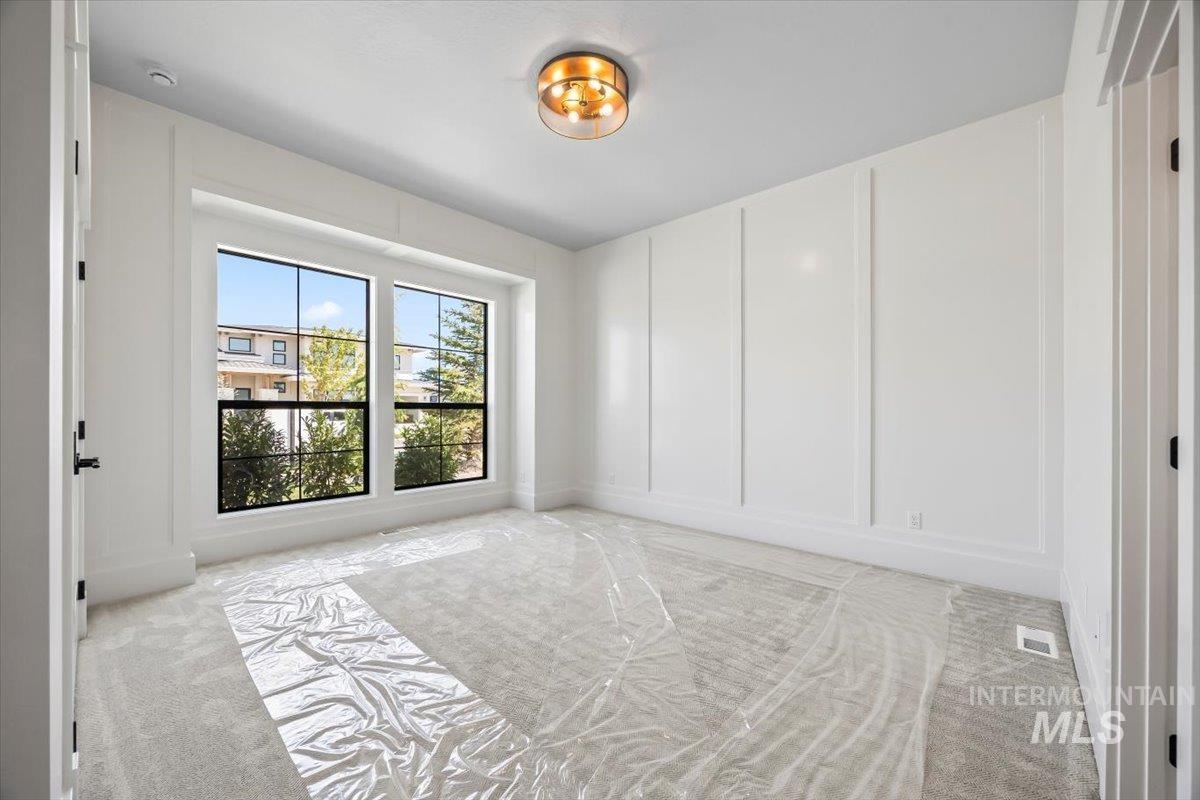 Spare room featuring a decorative wall and light carpet
