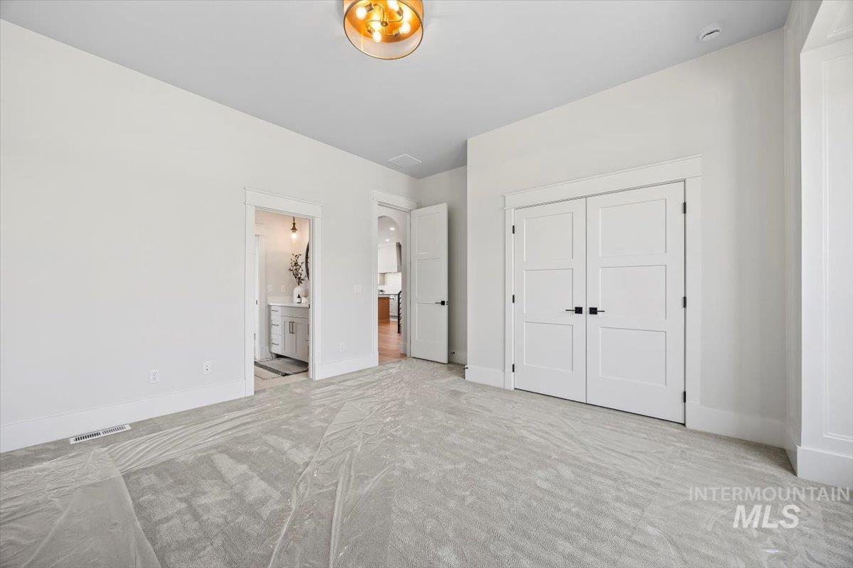 Unfurnished bedroom with carpet floors, a closet, and ensuite bathroom