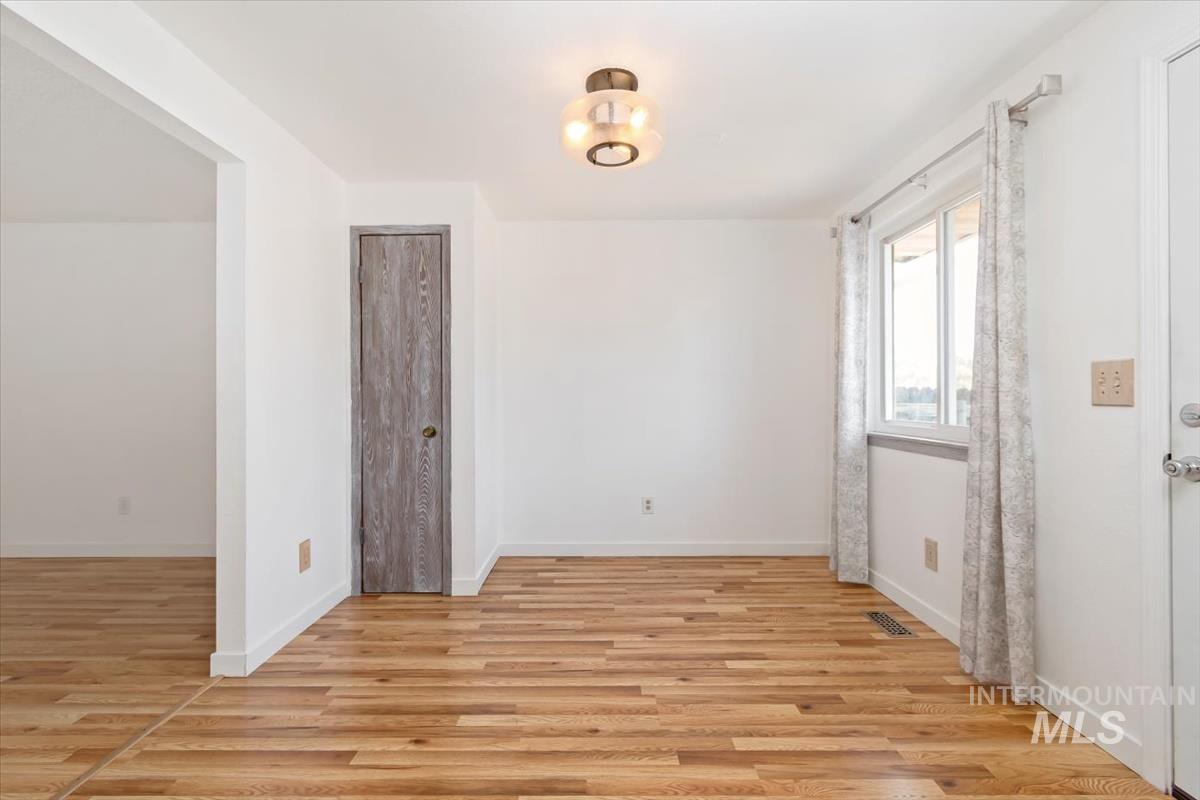 Unfurnished room with light wood-type flooring and baseboards