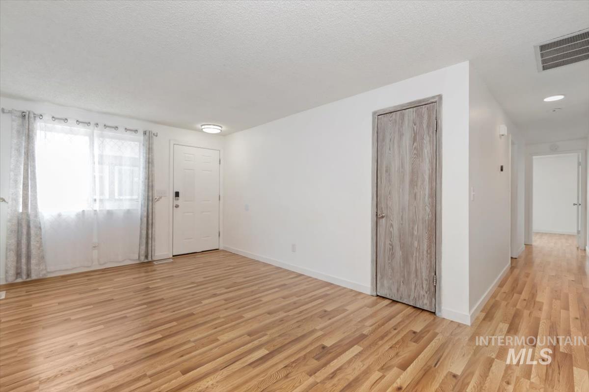 Entrance foyer featuring light wood-style floors and a textured ceiling