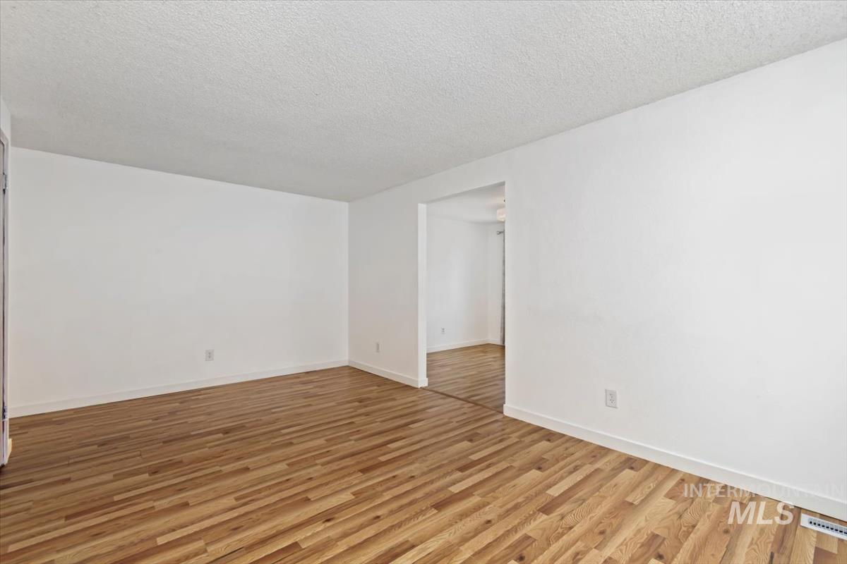 Spare room with light wood-style floors and a textured ceiling