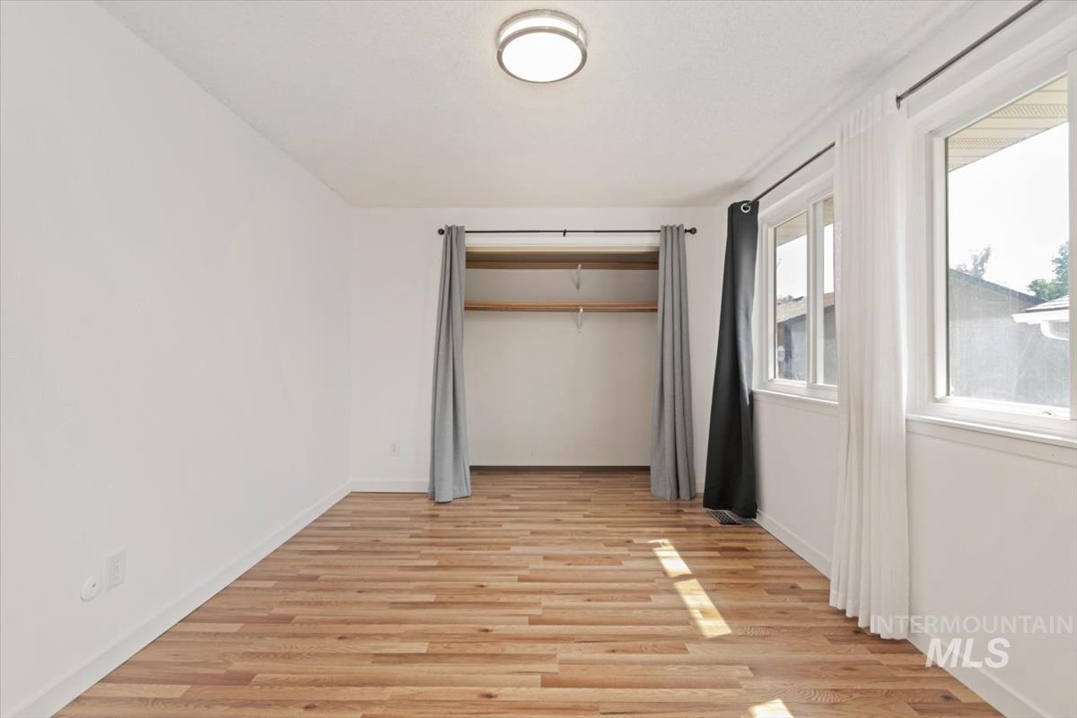 Unfurnished bedroom featuring light wood-style flooring and a closet